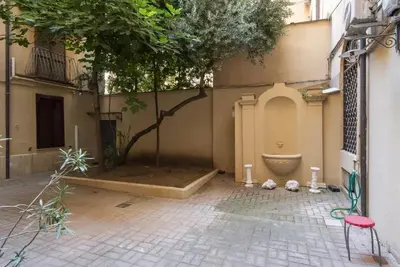 a courtyard with a tree and a tub in a building at Elegant loft at Piazza Vittorio in Rome