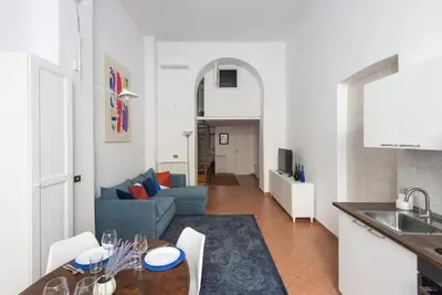 a kitchen and a living room with a blue couch at Elegant loft at Piazza Vittorio in Rome