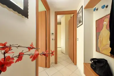 a hallway with a door and a plant with red flowers at Rome Family Comfort Hub in Rome