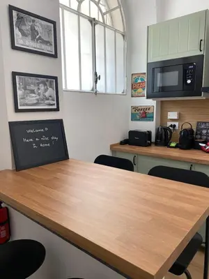 a room with a table with chairs and a microwave at A due passi dal Colosseo in Rome