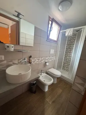 a bathroom with a sink and a toilet and a mirror at Lux of the Vatican in Rome
