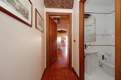 a hallway with a bathroom with a sink and a toilet at Classic roman home next to Popolo Square in Rome