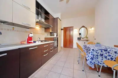 a kitchen with a table and a dining room at Typical roman home in Testaccio in Rome