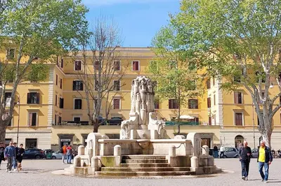 a statue in front of a building with people walking by it at Typical roman home in Testaccio in Rome