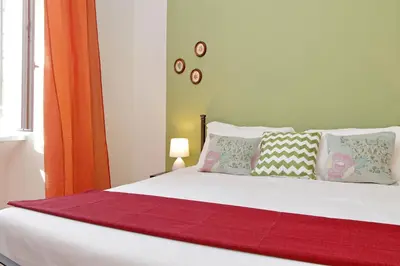 a bedroom with a bed with a red blanket on it at Typical roman home in Testaccio in Rome