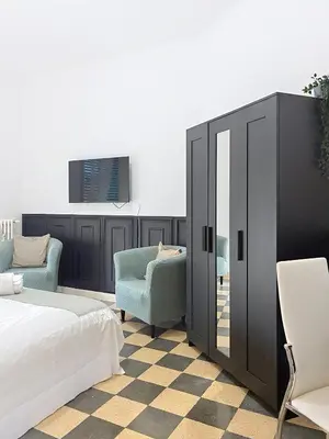 a bedroom with a bed and two chairs and a mirror at Villa Carpegna House 10 Minuti from Vatican San Peter in Rome