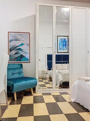a bedroom with a blue chair and a bed at Villa Carpegna House 10 Minuti from Vatican San Peter in Rome