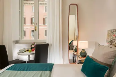 a bedroom with a bed and a mirror and a table at Boutique Hotel Atelier '800 in Rome