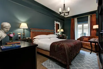 a bedroom with a king sized bed and a desk at Rocco Forte Hotel De La Ville in Rome