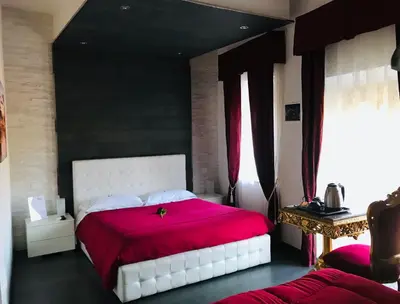 a bedroom with a white bed with a red blanket at Royal Rooms in Rome