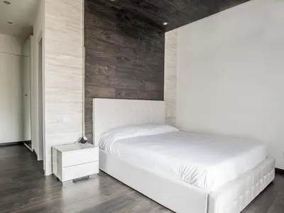 a bedroom with a white bed and a wooden wall at Royal Rooms in Rome