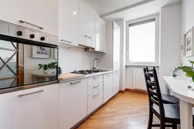 a kitchen with white cabinets and a counter and a window at Romaviva Luxury Attic Apartment - San Giovanni in Laterano - Metro A C - Central Rome in Rome