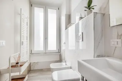 a white bathroom with a toilet and a sink at Roma Vatican Suites Inn in Rome