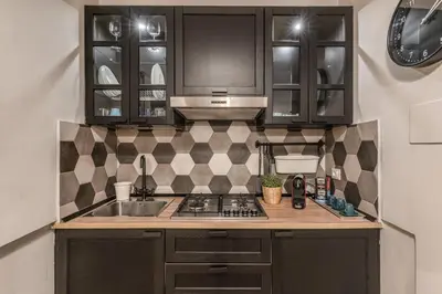 a kitchen with a sink and a stove and cabinets at Fresh House Castel Sant' Angelo in Rome