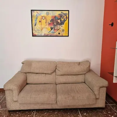 a brown couch in a living room with a picture on the wall at La casetta di Laura in Rome