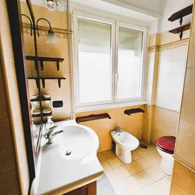 a bathroom with a sink and a toilet and a window at La casetta di Laura in Rome
