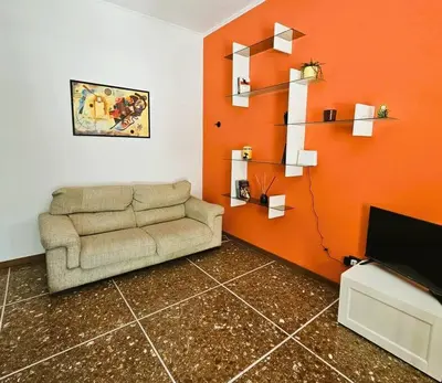 a living room with a couch and an orange wall at La casetta di Laura in Rome
