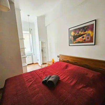 a bedroom with a red bed with two towels on it at La casetta di Laura in Rome
