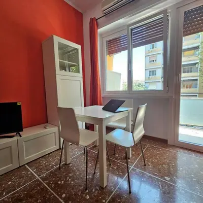 a room with a table with chairs and a laptop at La casetta di Laura in Rome