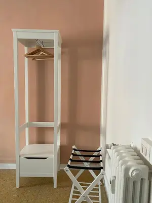 a closet with a white cabinet next to a bed at Suite 10 Parioli in Rome