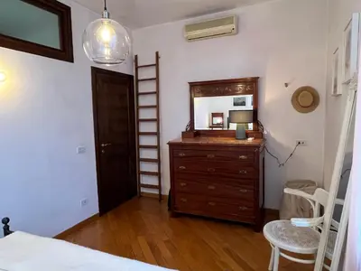 a bedroom with a dresser and a mirror and a ladder at A Terrace With a View in Rome