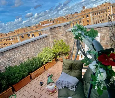 a small patio with a garden with a teddy bear sitting on a chair at Ave Roma Suite in Rome