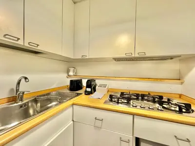 a kitchen with white cabinets and a stove and a sink at Boutique Trevi Apartment in Rome