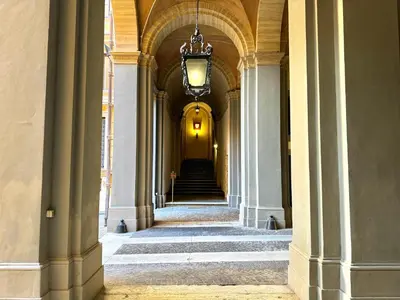 a hallway of a building with columns and a chandelier at Boutique Trevi Apartment in Rome