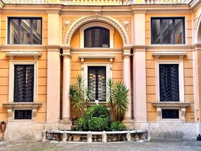a yellow building with trees in front of it at Boutique Trevi Apartment in Rome