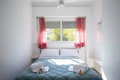 a bedroom with a bed with red curtains and a window at Garbatella Bridge Apartment in Rome