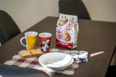 a table with a plate of food and two cups and a bag of snacks at Garbatella Bridge Apartment in Rome