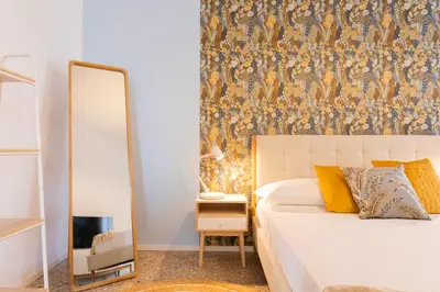 a bedroom with a mirror and a white bed with a mirror at Flora Cozy Flat close to Metro in Rome