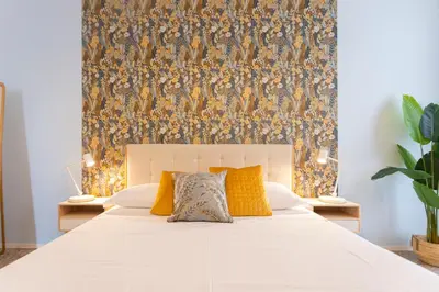 a bedroom with a large white bed with a wallpaper at Flora Cozy Flat close to Metro in Rome