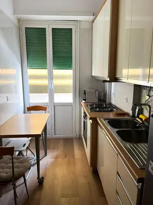 a kitchen with a table and a sink and a table and chairs at Viale4Venti in Rome