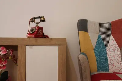 a red telephone sitting on top of a table next to a chair at We Home - La Dimora di Portonaccio - Roma in Rome