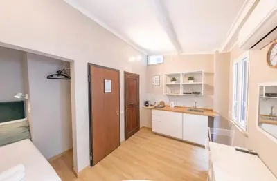 a kitchen with white walls and a wooden door at Domus Augustea - 3 Floor in Rome