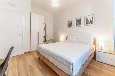 a white bedroom with a large bed and a desk at Lorena Cozy Rooms - Ospedale Gemelli - WiFi in Rome