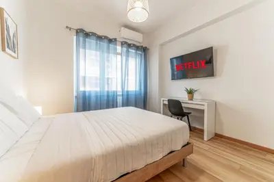 a bedroom with a bed and a desk with a tv at Lorena Cozy Rooms - Ospedale Gemelli - WiFi in Rome