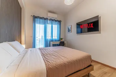 a bedroom with a bed and a tv on the wall at Lorena Cozy Rooms - Ospedale Gemelli - WiFi in Rome