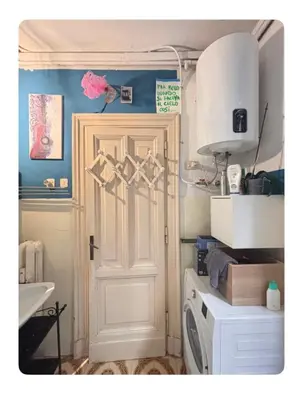 a bathroom with a white door and a washing machine at La stanza di Marta in Rome