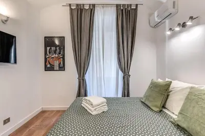 a bedroom with a bed and a window with curtains at Fresh House San Lorenzo in Rome