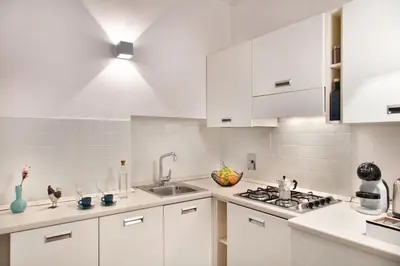 a white kitchen with white cabinets and a sink at Appartamento Roma Coronari Suite in Rome