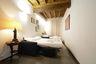 a room with two beds and a table with a lamp at Appartamento Roma Coronari Suite in Rome