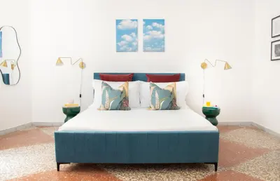 a bedroom with a blue bed with pillows at Appartamento di Design - Metro Re di Roma in Rome