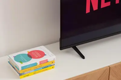 a stack of books sitting next to a television at Appartamento di Design - Metro Re di Roma in Rome