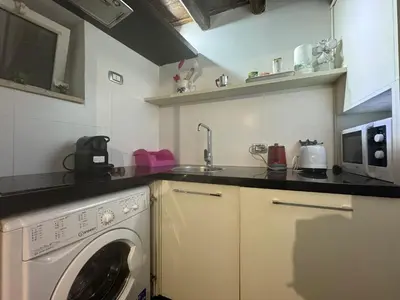 a kitchen with a washing machine and a microwave at In Ancient Rome Apartment in Rome