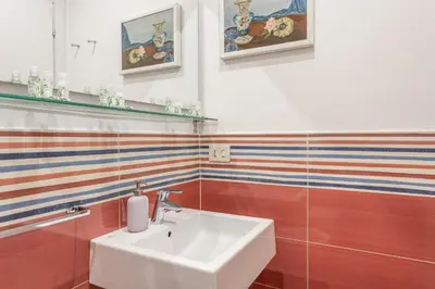 a white sink in a bathroom with colorful stripes at Elegantis Des Artistes Apartment in Rome