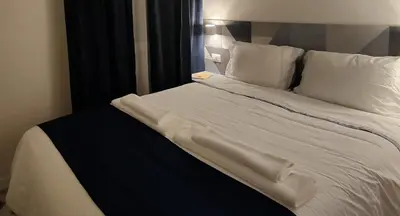a bed with white sheets and pillows in a room at Rare Seed Trastevere in Rome