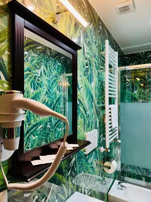a bathroom with a large mirror and a sink at Milazzo Suites in Rome