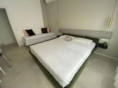 a bedroom with two beds and a couch at Casa vacanze Belsito in Rome